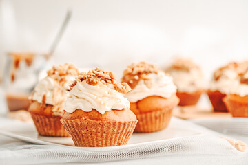 Muffin. Creme muffins with caramel and nuts. Creme on the top of muffin. Caramel muffins.  
