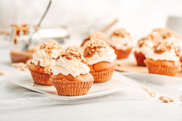 Muffin. Creme muffins with caramel and nuts. Creme on the top of muffin. Caramel muffins.  