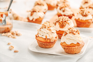 Muffin. Creme muffins with caramel and nuts. Creme on the top of muffin. Caramel muffins.  