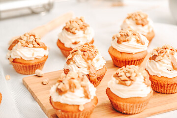 Muffin. Creme muffins with caramel and nuts. Creme on the top of muffin. Caramel muffins.  
