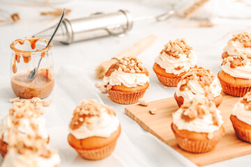 Muffin. Creme muffins with caramel and nuts. Creme on the top of muffin. Caramel muffins.  