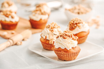 Muffin. Creme muffins with caramel and nuts. Creme on the top of muffin. Caramel muffins.  