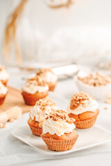 Muffin. Creme muffins with caramel and nuts. Creme on the top of muffin. Caramel muffins.  