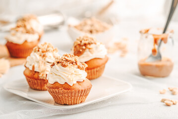 Muffin. Creme muffins with caramel and nuts. Creme on the top of muffin. Caramel muffins.  