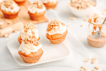 Muffin. Creme muffins with caramel and nuts. Creme on the top of muffin. Caramel muffins.  