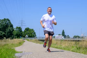 Foto op Plexiglas Low angle view of a senior man working out jogging © michaelheim