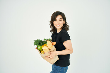 cute brunette package with groceries in a supermarket vegetable