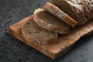 Sliced rustic style ciabatta with rye flour on olive board