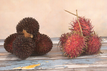 Rambutan and pulasan fruits side by side. Both belongs to the soapberry family. Selective focus...