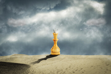 Chess white queen in the sand dunes. Cloudy sky. Leadership concept. Success. Abstraction. Business.