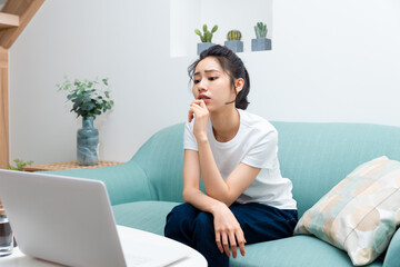 Asian young girl sitting and thinking at the computer