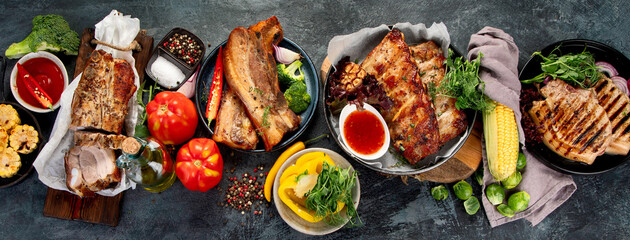 Fototapeta na wymiar Assortment of grilled pork meat with vegetables on dark grey background.