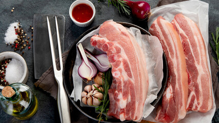 Raw pork belly on dark gray background. Organic gourmet food concept.
