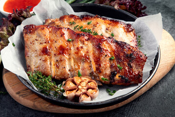 Roasted ribs with snacks and sauce on dark gray background. Gourmet cooking food concept.