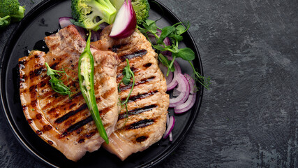 Sliced roasted pork meat on dark gray background. Organic gourmet food concept.