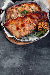 Roasted ribs with snacks and sauce on dark gray background. Gourmet cooking food concept.