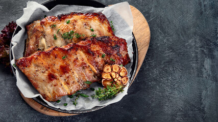 Roasted ribs with snacks and sauce on dark gray background. Gourmet cooking food concept.