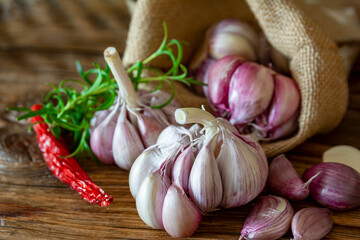 garlic bulbs and cloves arranged on an old board.