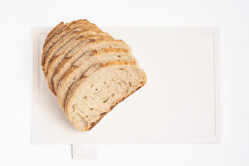 Pieces of bread on a cutting board top view on white clean plastic cutting board 