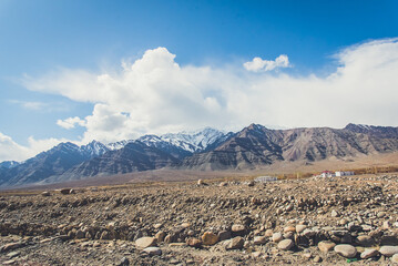 Beautiful panoramic view of a mountainside lit at the sunset period and also including of a snow found high up in the mountain peaks.