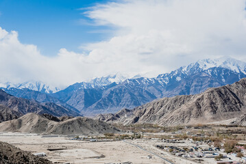 Beautiful panoramic view of a mountainside lit at the sunset period and also including of a snow found high up in the mountain peaks.