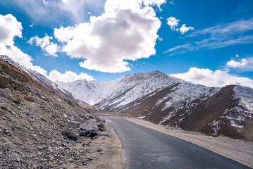 Beautiful panoramic view of a mountainside lit at the sunset period and also including of a snow found high up in the mountain peaks.