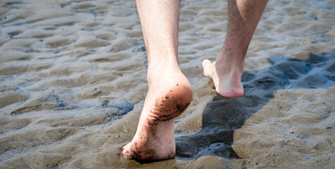 male feet walking on the sand