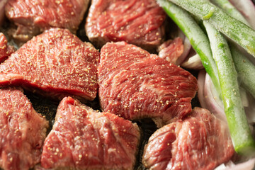 Seasoned raw meat and vegetables in a cast iron pan