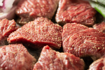 Seasoned raw meat and vegetables in a cast iron pan