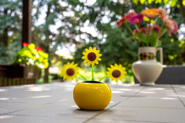 View on a solar powered plastic artificial sunflower moving by the sunlight