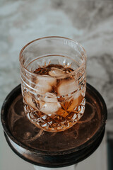  Glass of whisky from old wooden cask at the dark background.