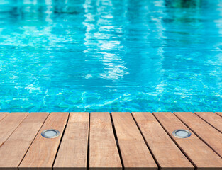 Piscine bleue avec plage bois et spots d’éclairage intégrés