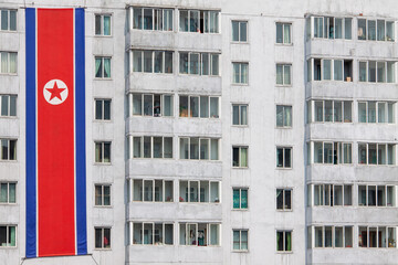 The North Korean national flag displayed vertically against a wall