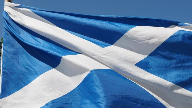 Close-up of flag of Scotland waving during hard wind. Edinburgh, Scottish flag in a street in UK. Video 4k resolution. 