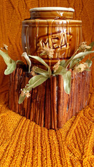 a barrel of honey on an orange knitted background