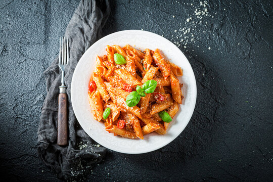 Hot pene bolognese with parmesan and basil. Italian cuisine.