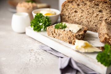 Freshly baked artisan multigrain bread with butter and pate. Breakfast with coffee, sliced bread, butter and liver pate.