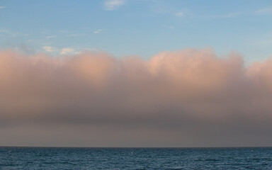 Naklejka na ściany i meble A fog bank at sea at sunset