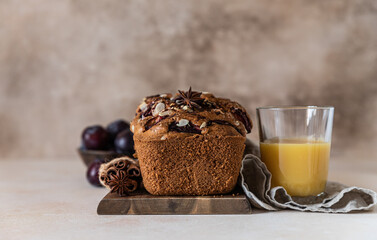 Homemade spicy plum cake decorated with almond on a wooden serving board, concrete background. Loaf cake with plum, spices and almond.
