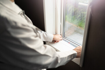 窓枠を計るリフォーム業者のイメージ コピースペースあり