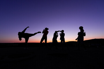 Fototapeta na wymiar silhouette of a group of children jumping in the sunset