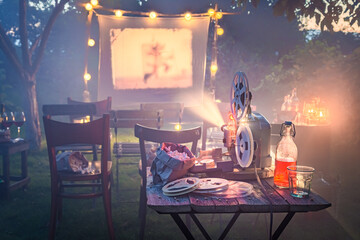 Cozy summer cinema with vintage projector in small garden