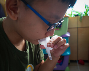 Test Covid at home. A young boy self test for COVID-19 home test kit. Coronavirus saliva test for...