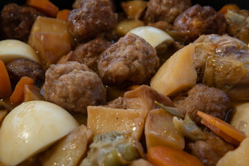 Close-up of a stew of meat balls with Mediterranean vegetables in a clay pot. Image of Mediterranean gastronomy from the island of Mallorca, Spain