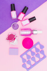 A set of cosmetics for manicure and pedicure on a pink and purple background. Gel varnishes, nail...