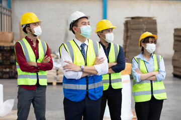 portrait factory workers wearing medical face mask and looking to something in warehouse storage