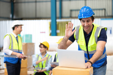 engineer or factory worker using laptop computer and talking to someone