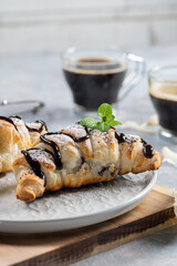Homemade croissant served with black coffee or americano. Delicious breakfast with fresh croissant and coffee. Croissant and black coffee and chamomile with copy space in top view or flat lay style.