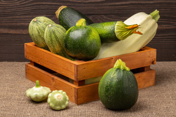 zucchini and squash in a box on a wooden table