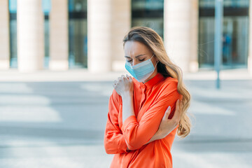 Caucasian girl with closed eyes in medical mask with headache